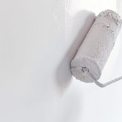 Male hand painting wall with paint roller. Painting apartment, r Male hand painting wall with paint roller. Painting apartment, renovating with white color paint